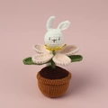 Close-up of hand-knitted bunny flower potted plant showing intricate yarn texture and stitches - Pink