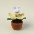 Detailed macro shot of handmade crochet white rabbit flower in a knitted brown pot - Yellow