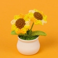 Handgefertigte gehäkelte Sonnenblume im weißen Keramiktopf als dekorative Zimmerpflanze - Verlaufsgelb