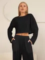 Detail van zwarte tweedelige set met hol borduurwerk op crop top en broek met hoge taille - S / Zwart
