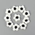 Detail von 10 handgehäkelten schwarz-weißen Puffblumen für DIY-Zubehör und Dekoration - Weiße Blütenblätter Schwarzer Staubbeutel