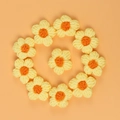 Nahaufnahme von 10 handgehäkelten Makronen-Puffblumen für DIY-Haarspangen und Mode - Gelbes Blütenblatt