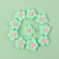 Macro detail of 10 handmade crochet macaron flowers in mint green and soft pink yarn - Puff Flower - Fruit Green Petals