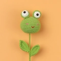Handmade crochet frog plant flower decoration with green leaves on orange background - Frog Style