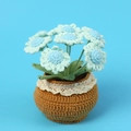 Close-up of handmade crochet light blue potted flowers with lace decorated brown pot - Blue