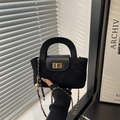 Zwarte gewatteerde crossbodytas met gouden ketting en metalen slot in natuurlijk licht - Zwart