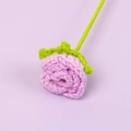 Close-up of handmade purple crochet rose with detailed knitted texture and green stem - Purple