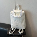 White fashion backpack with butterfly prints and elegant ruffle trim in a variant view - White