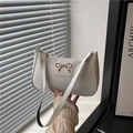 Chic cream white underarm bag with a gold metal bow and glossy finish - White