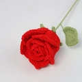 Close-up of handmade crochet red rose with detailed knitted textures and green leaf - True Red