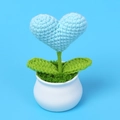 Macro shot of handmade crochet heart potted plant with intricate yarn texture on blue base - Blue Heart Potted Plant