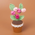 Detail van handgehaakte zonnebloemen in pot met kanten rand en realistische groene bladeren - Roze Bosbes Potplant / Roze Bosbes