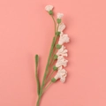Fleur de freesia rose clair crochetée à la main avec tige tricotée verte sur fond corail - Type multi-fleurs / Rose Coréen