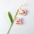 Handmade crochet pink pig flower bouquet with green leaves on white background - Lily of the Valley Pink Pig Style
