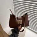 Borsa sottobraccio in pelle opaca marrone scuro con fibbia geometrica dorata su sfondo moderno - Marrone