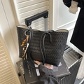 Schwarze geflochtene Tragetasche mit Perlenanhänger auf silbernem Koffer für Reisen - Einzelne Tasche / Schwarz