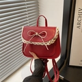 Red faux leather crossbody bag with cream lace trim and sweet bow detail in hand - Red