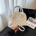 White shell handbag with embossed checkerboard pattern and gold hardware on daily desk - White