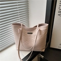 Borsa tote rosa con stampa monogramma e logo metallico in un ambiente d'interni curato - Rosa