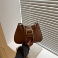 Retro brown leather handbag for women featuring a large golden metal buckle closure - Tan