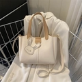 Chique beige draagtas met bruine handvatten en mode-logo op een witte blazer - Wit