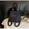 Detalle de mochila de nailon negra con bordado Ai Mei, cuentas de cordón y toques de color - Negro