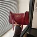 Red patent leather baguette bag with golden bow buckle decoration in minimalist style - Red