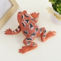 Realistic orange frog stress relief toy with black and white spots on a desk - Brown Frog / Brown