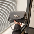 Minimalist textured dark grey crossbody bag with silver buckle in aesthetic lighting - Black