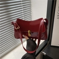 Deep red patent leather underarm saddle bag with gold metal clasp for a retro French look - Red