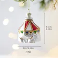 Circus tent shaped glass Christmas ornament with colorful stripes hanging on pine tree - Circus