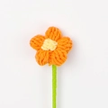 Gros plan d'une fleur bouffante de 4cm crochetée à la main, pétales orange et cœur jaune - Orange
