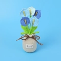 Detail of handmade crochet calla lily in blue gradient with a rustic woven pot - Gradient Blue (Large Crochet Vase)