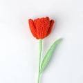 Detailed view of hand-knitted red tulip flower with realistic crochet texture and green stem - Orange