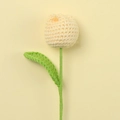 Close-up of handmade crochet tulip in beige yarn with green leaves on soft yellow background - Light Yellow