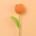 Close-up of a hand-knitted orange tulip with green leaves made from premium cotton yarn - Orange