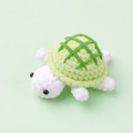 Handmade crochet turtle doll plush toy with green shell on soft green background - Green Biscuit (Turtle Doll)