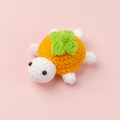 Close-up of handmade crochet turtle doll featuring orange shell and green leaf detail - Orange Persimmon (Turtle Doll)