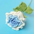 Detailaufnahme einer handgehäkelten blau-weißen Rose mit weicher Wollstruktur - Verlauf Weißblau