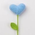 Macro detail of a hand-knitted blue heart flower with crochet texture and green stem - Blue Heart Bouquet (Green Leaves)