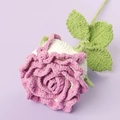 Handmade pink and white crochet rose flower with green leaves on lilac background - White Purple
