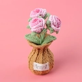 Detail of three pink crocheted roses in a pot with a label stating Handmade WITH LOVE - Gradient Pink-Rose Brown Vase