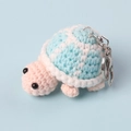 Detailed close-up showing the handmade crochet texture of the light blue turtle keychain - Blue