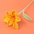Makro-Detail einer handgehäkelten orangefarbenen Lilie mit gelben Staubblättern und Textur - Orange