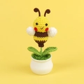 Détail d'une abeille au crochet faite main dans un pot blanc sur fond jaune - Plante en Pot Abeille