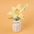 Detail of handmade crochet yellow lily in white vase with pink ribbon bow on orange background - Yellow Lily-White Vase