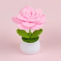 Close-up of handmade pink crochet rose in white pot with soft pink background texture - Pink