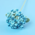 Close-up of handmade blue crochet hydrangea with pearl beads and green leaves - Hydrangea Branch / Gradient Light Blue