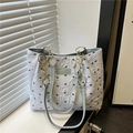 Borsa tote azzurra con stampe di fiocchi neri e tracolla a catena su davanzale - Blu