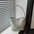 Hellgrüne Stoff-Beuteltasche mit Blumenmuster und stilvollem Rundgriff bei sanftem Licht - Grün